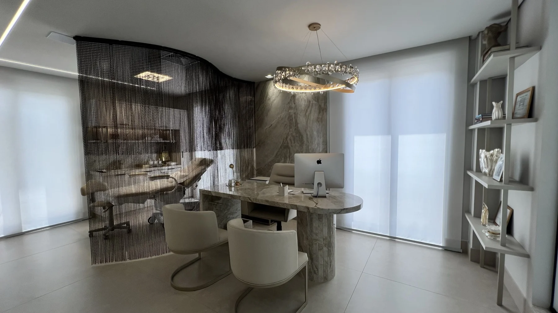 Consultório com mesa em mármore e lustre de cristal