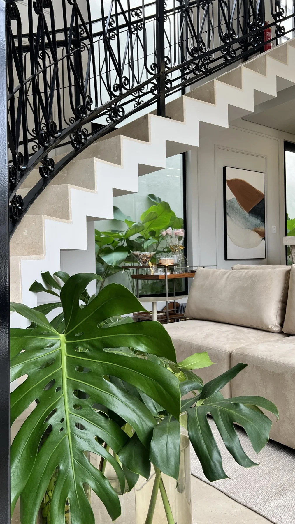 Escadaria em travertino com sofá e planta monstera