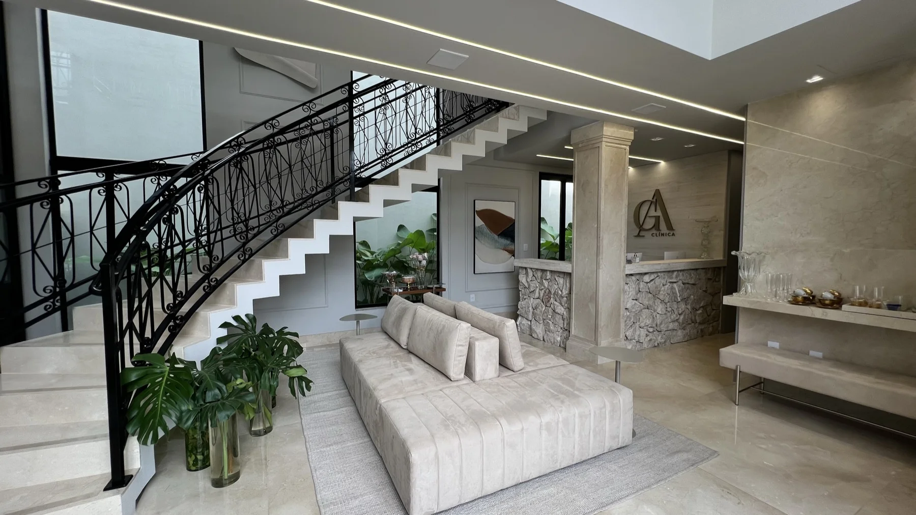 Hall com escadaria e logotipo GA em travertino